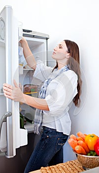 Young woman looking for something in the fridge