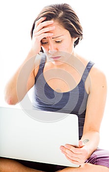 Young woman looking stressed using laptop