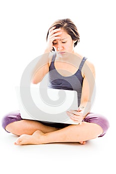 Young woman looking stressed using laptop