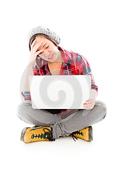 Young woman looking stressed using laptop