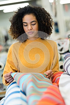 Young woman looking at stripe colored fabric photo