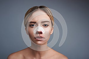 Young woman looking terrible while having bloody nose