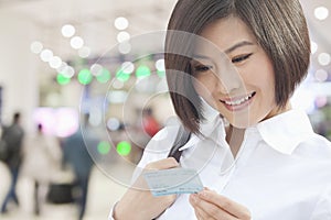 Young Woman Looking at a Train Ticket
