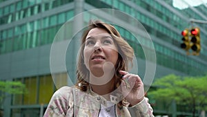 Young woman looking up at skyscrapers