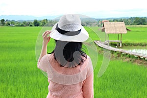Young Woman Looking at Vibrant Green Rice Field in Nan Thailand