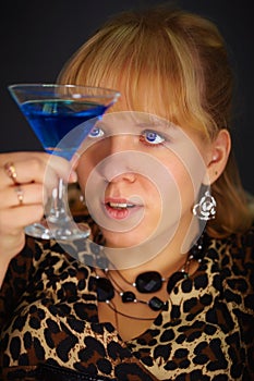 Young woman looks at glass with unusual cocktail