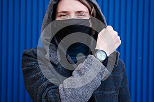 A young woman looks at her watch with an emblem of ecology