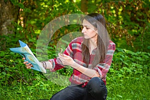 A young woman looks at a map while hiking.