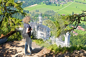 Young woman looks at Neuschwanstein castle, Bavaria, Germany