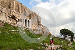 Young woman looks at Parthenon on the Acropolis of Athens, Greece. The famous ancient Greek Parthenon is the main tourist