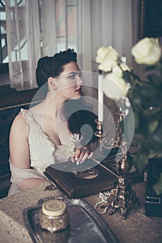 Young woman looks at a photo album. Vintage style, retro interior