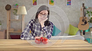 Young woman looks at tomatoes, which cause an allergic reaction.Allergy to tomatoes