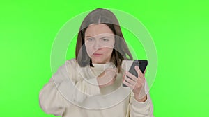 Young Woman with Loss on Smartphone on Green Background