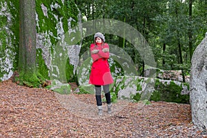 Young woman lost on a forest shivering with cold and embracing or holding herself