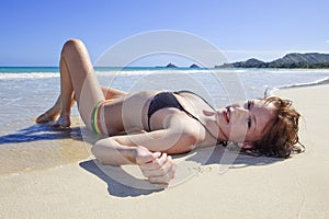 Young woman lounging at the beach photo