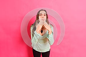 Young woman with loving attitude blows kisses with her hand looking for a partner during her single life, isolated on pink