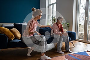 Young woman loving mother trying to speak with upset depressed teen daughter