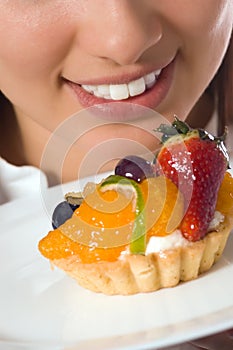 Young woman with low-calorie fruit cake photo