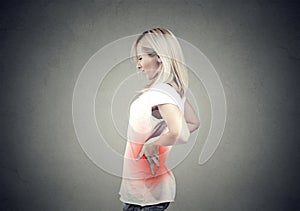 Young woman with lower back pain colored in red