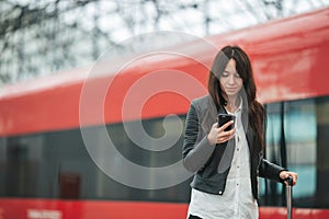 Young woman with luggage at a train station waiting for express train