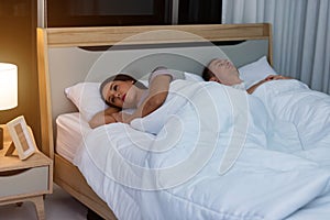 Young woman lying on the bed feeling sad