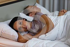 Young woman lying on the bed feeling sad