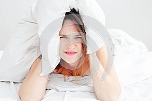 Young woman lying in bed with a headache