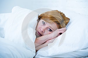 Young woman lying in bed sick unable to sleep suffering depression and nightmares insomnia sleeping disorder photo