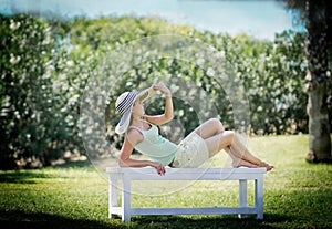 Young woman lying on bench in park