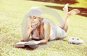 Young woman lying with book outdoors