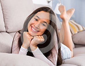 Young woman lying on cozy sofa
