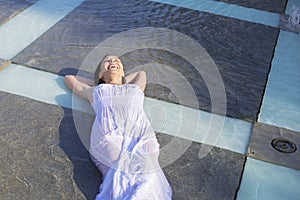 young woman lying down in fountain during summer heat