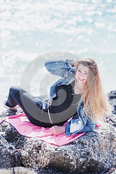 Young woman lying down on the stone at beach  bahamas