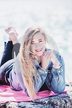 Young woman lying down on the stone at beach bahamas