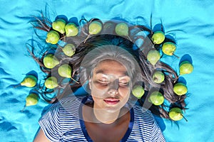 Young woman lying eyes closed pears in black hair