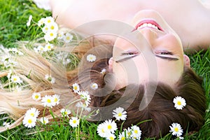 Young woman lying on grass with flowers in the park
