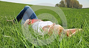 Young woman lying on green meadow