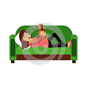 Young woman lying on an green sofa and playing with her puppy Illustration