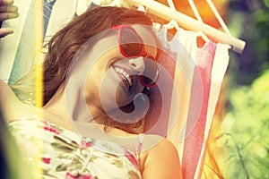 Young woman lying in a hammock in garden.