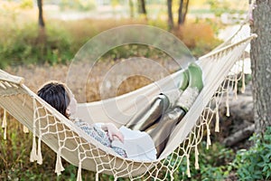 Young woman lying in a hammock outdoors in autumn