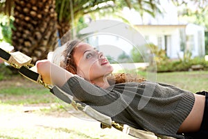 Young woman lying in hammock outside house