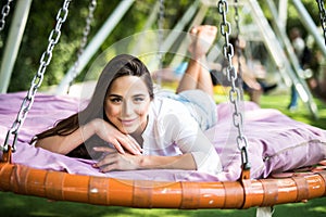 Young woman lying in a hammock in summer garden