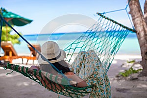 Young woman lying in the hammock on tropical beach