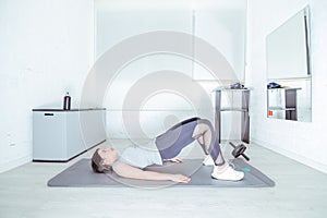 Young woman doing pelvic floor exercises in the gym photo