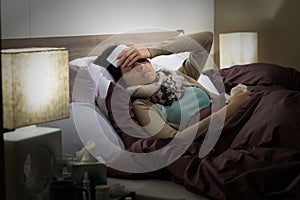 Young woman lying sick in bed cold