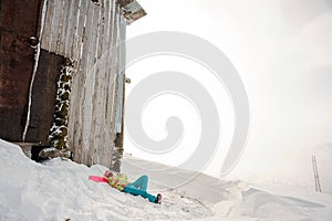 Young woman lying on the snowboard in the mountain resort