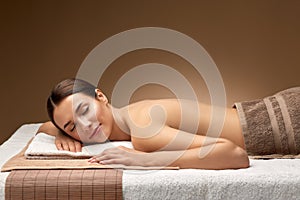 Young woman lying at spa or massage parlor
