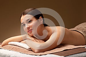 Young woman lying at spa salon or massage parlor