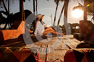 Young woman lying in straw hat in beach bar