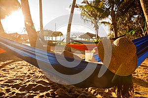 Young woman lying in straw hat in beach bar